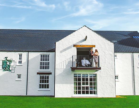 A couple on the balcony of the Mast Distiller's Suite at The Bushmills Inn