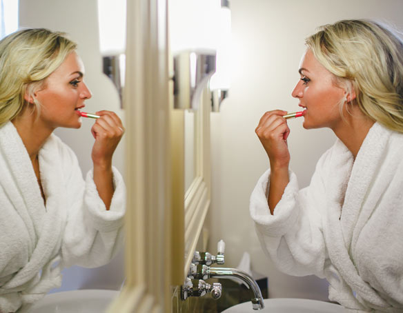 Woman doing make up in the mirror of The Tower Suite at The Bushmills Inn